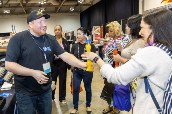 vendor greeting participant with drink